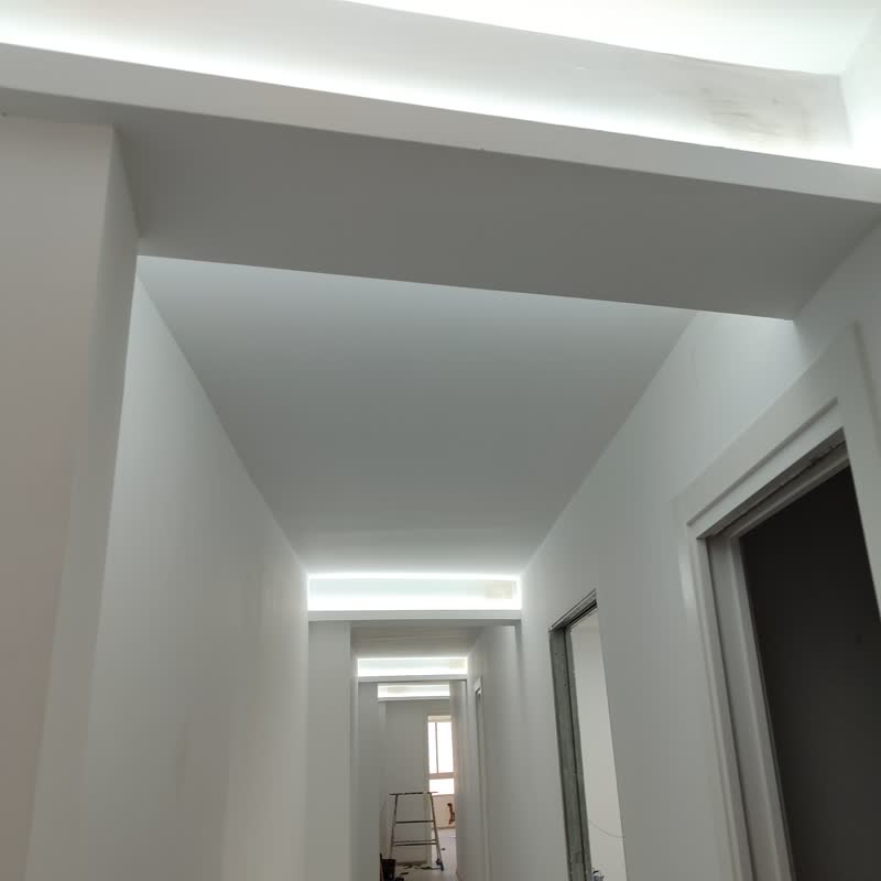 Pasillo terminado con iluminación LED indirecta integrada en el falso techo